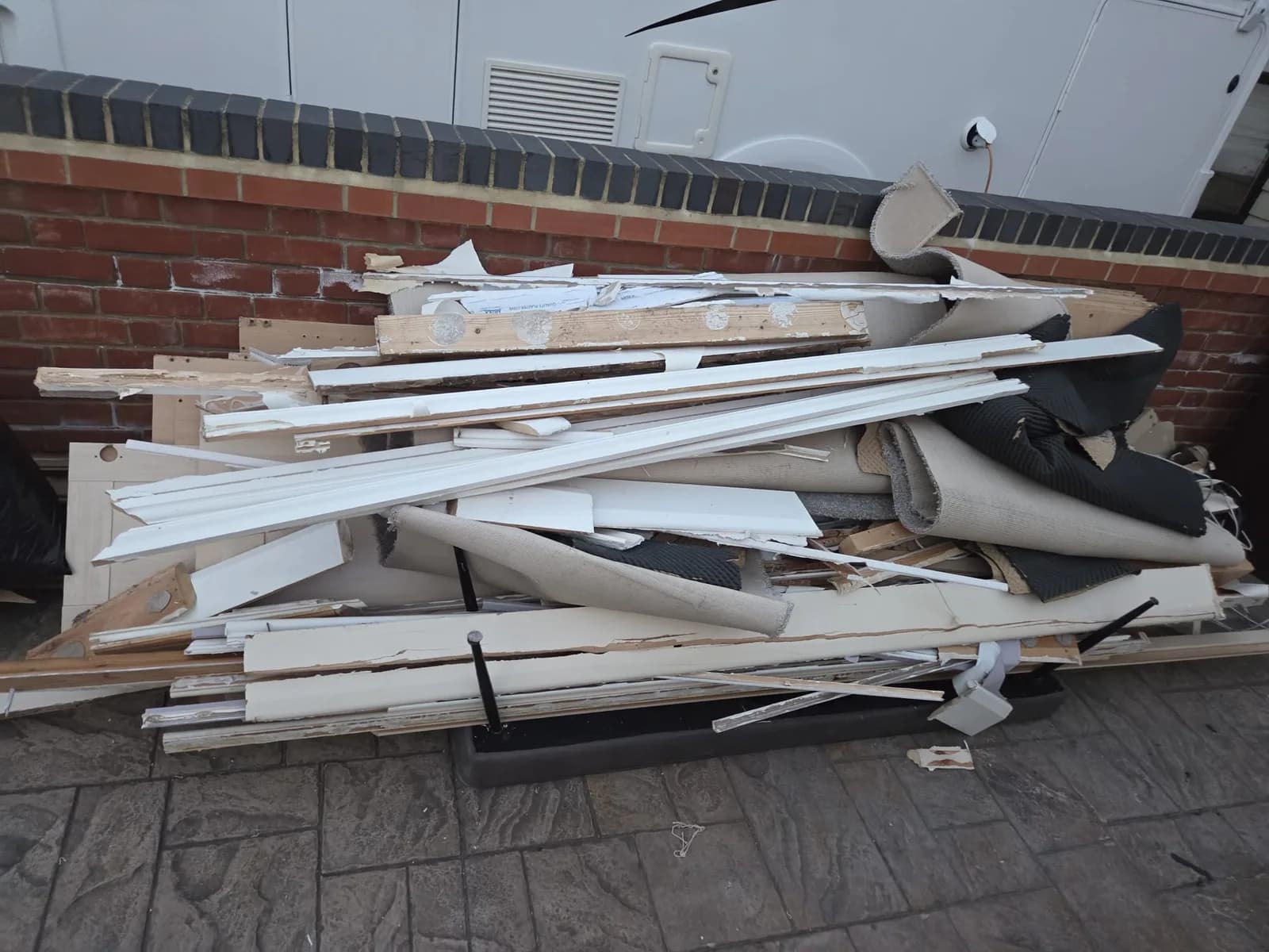 Builders waste in Gravesend — plasterboard, MDF and timber stacked ready for removal