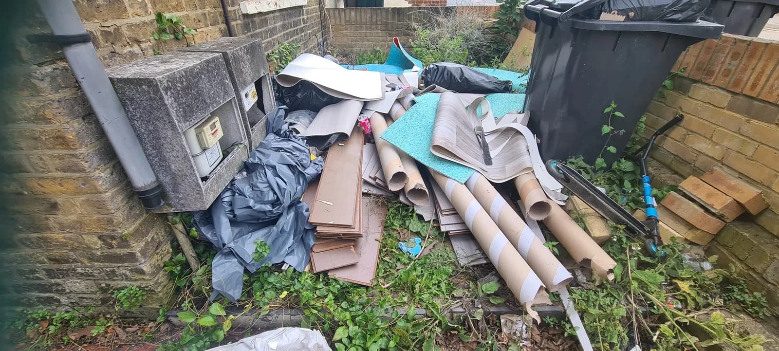 Old flooring, cardboard tubes and bits of wood cleared from the side of a house in Gravesend by Andy