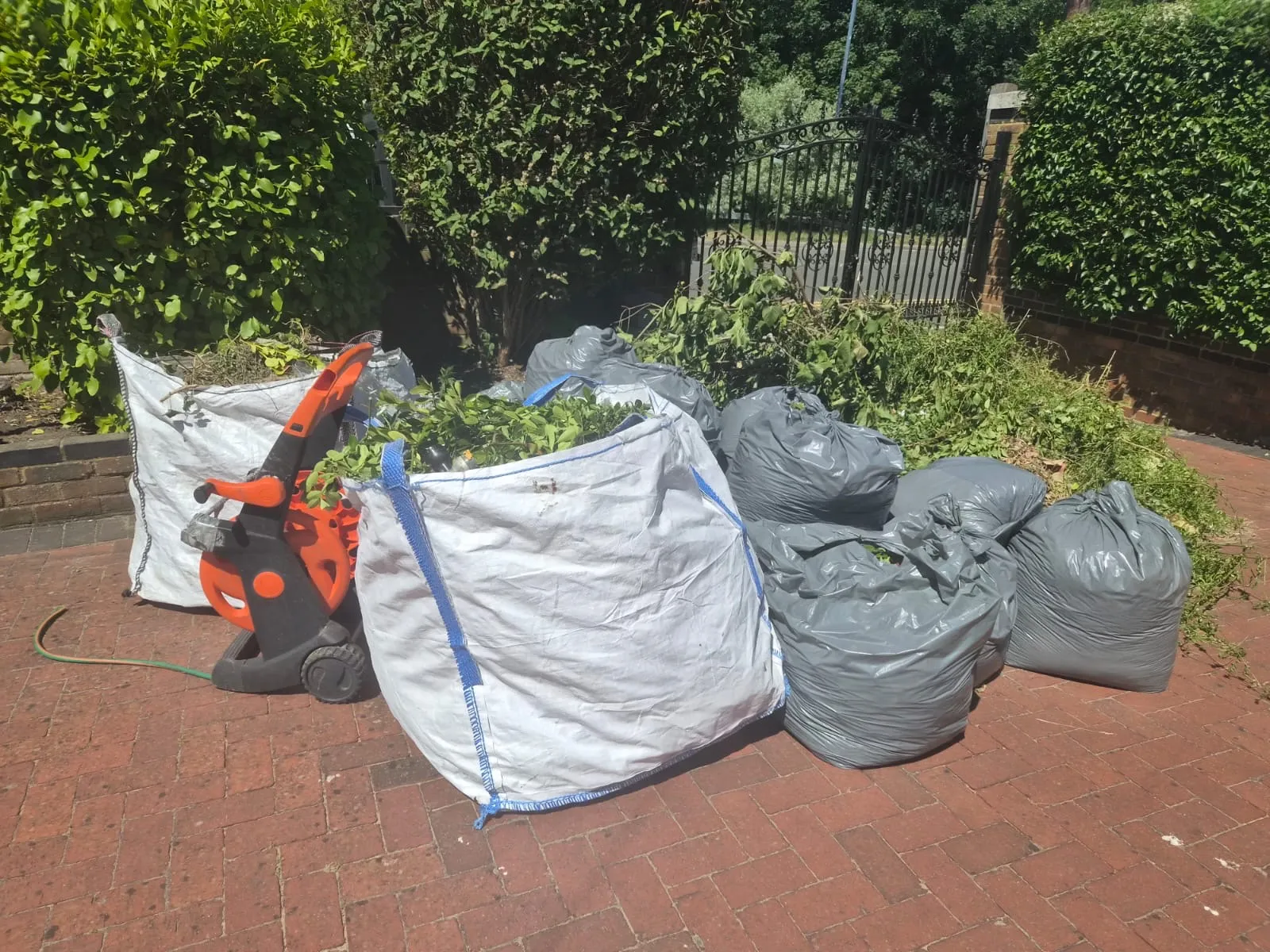 Bags and sacks of hedge cuttings and branches gathered on a driveway in Gravesend, ready for Andy to take away