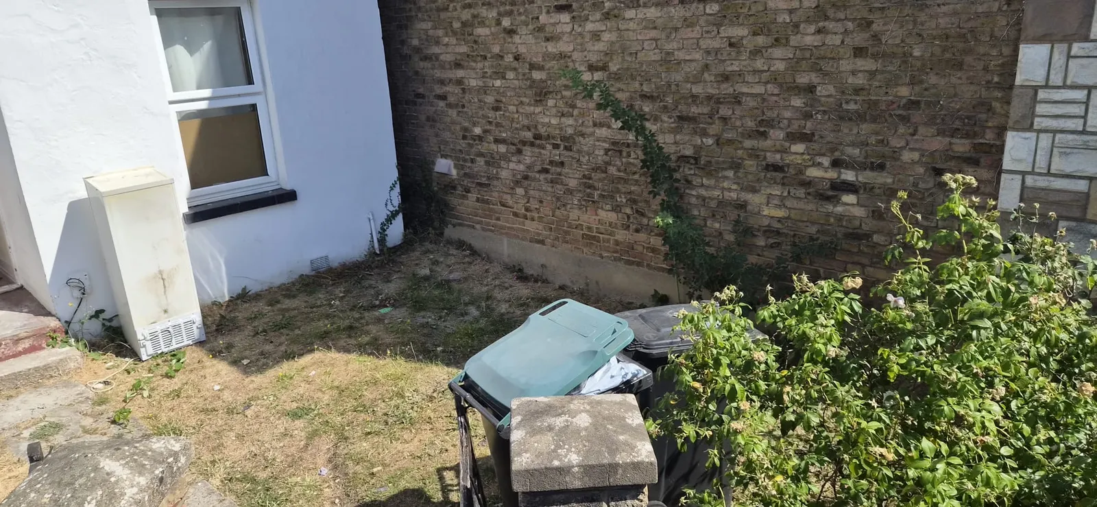The same front corner in Gravesend cleared, with just the wheelie bins left by the wall