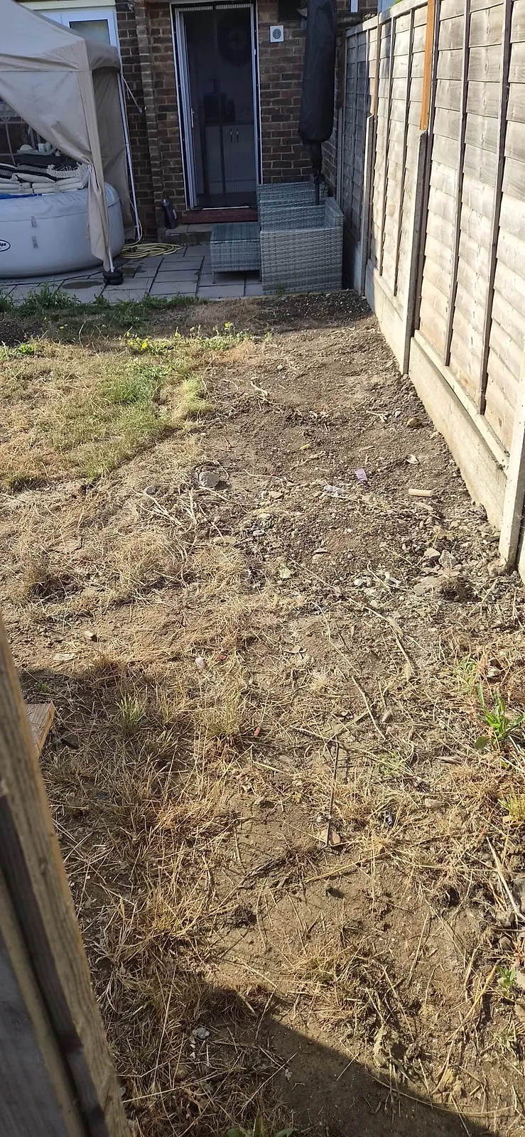 The same Gravesend back garden cleared to bare soil, hot tub and rattan furniture untouched