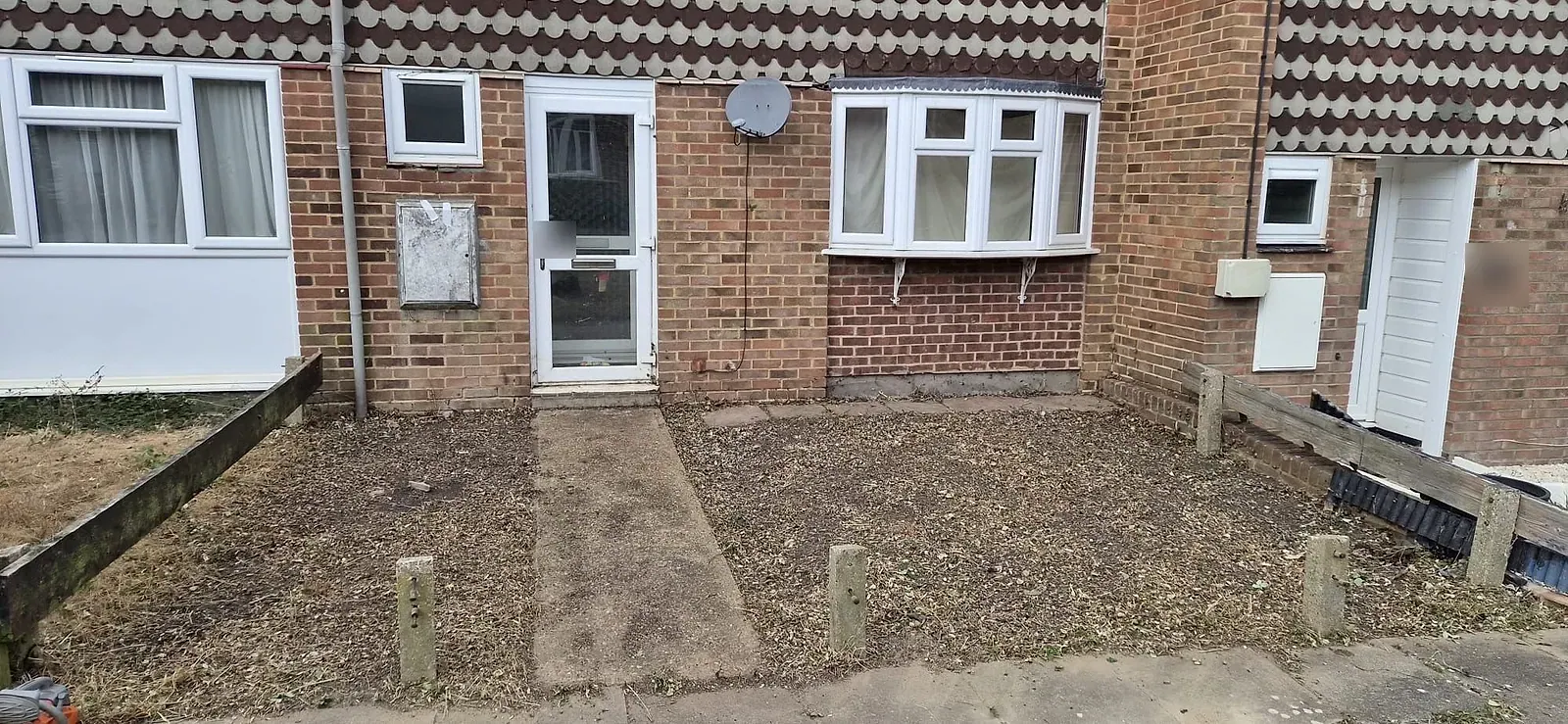 The same Gravesend front garden cut back to bare earth with the path, posts and bay window visible again